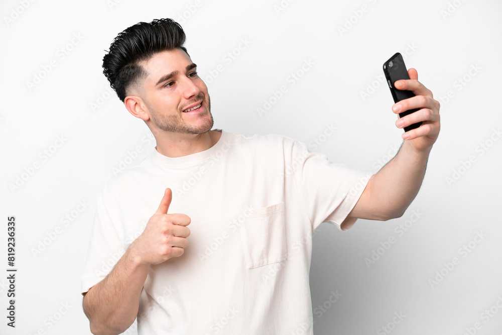 Young caucasian man isolated on white background making a selfie with mobile phone Young caucasian man isolated on white background making a selfie with mobile phone