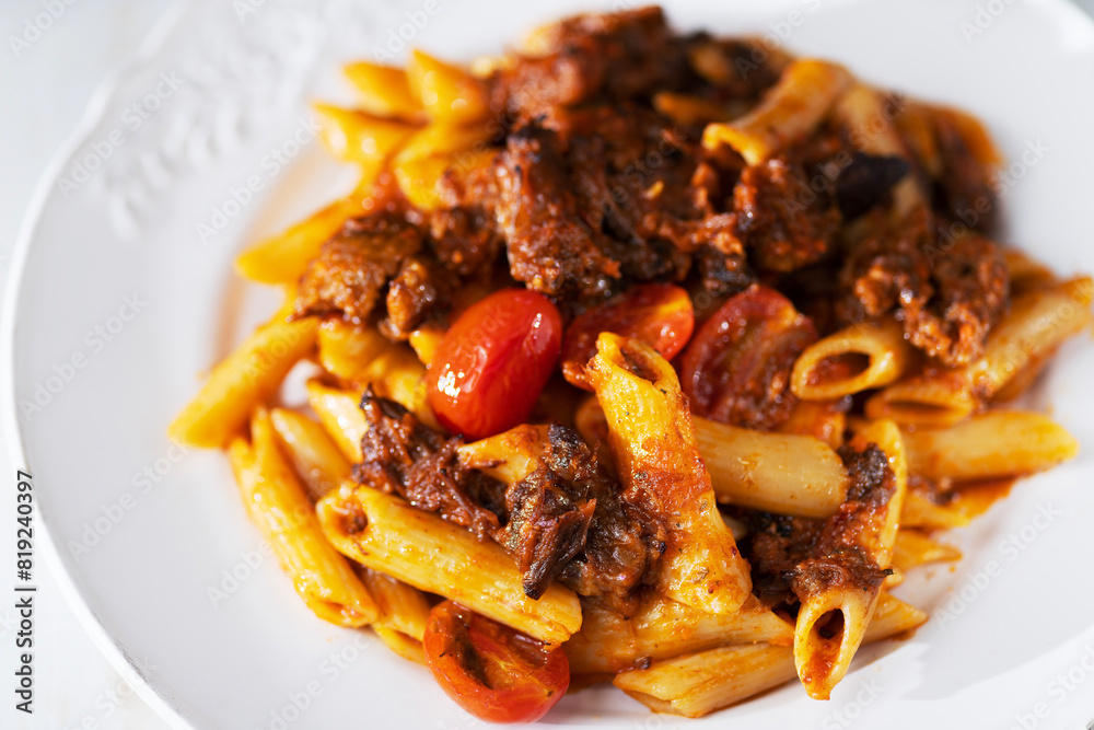 italian penne pasta in oxtail bolognese sauce