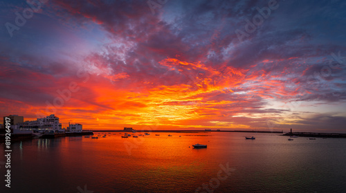 Arrecife, Lanzarote at sunset, offers a spectacular view of the harbour with moored boats and dramatic skies, creating a calm and picturesque atmosphere ideal for photographs.