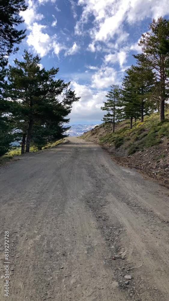 Road to Parking Hoya del Portillo on snowy mountains background, Sierra Nevada range, Andalusia, Spain Road to Parking Hoya del Portillo on snowy mountains background, Sierra Nevada range, Andalusia, Spain