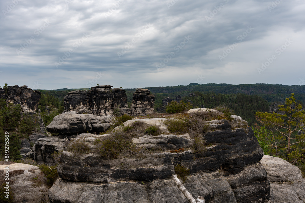A rocky mountain top with a cloudy sky in the background. The sky is overcast and the mountain is covered in rocks A rocky mountain top with a cloudy sky in the background. The sky is overcast and the mountain is covered in rocks