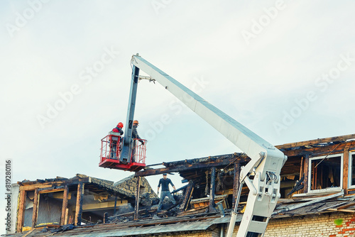 Obraz na plátně Unrecognizable  construction team operating crane to dismantle charred roof in the aftermath of fire