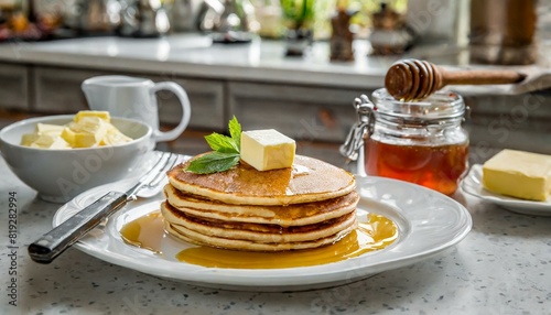 pancakes with maple syrup and butter on a white plate in a kitchen photo