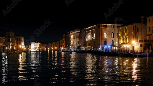 Night Venice  Italy. Canal Grande during sunset  beautiful lighting  reflection in the water  houses along the canal  gondolas stand in a row on the pier.