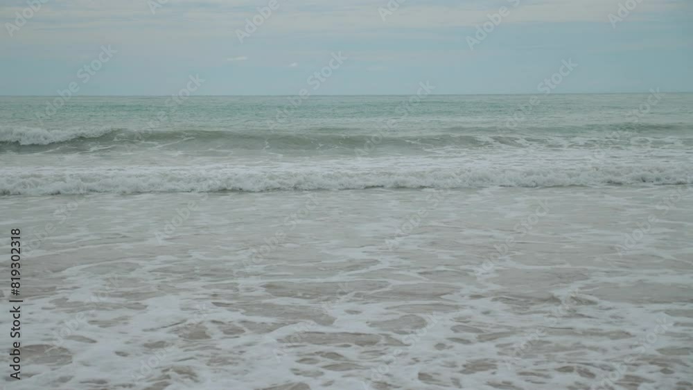 Calm ocean waves gently lapping against sandy shore under peaceful, cloudy sky. Serene and tranquil coastal scene. Ocean waves rolling onto beach with gentle foam. Tranquility and nature. Calm ocean waves gently lapping against sandy shore under peaceful, cloudy sky. Serene and tranquil coastal scene. Ocean waves rolling onto beach with gentle foam. Tranquility and nature.