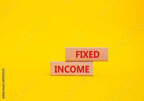 Fixed Income symbol. Concept word Fixed Income on wooden blocks. Beautiful yellow background. Business and Fixed Income concept. Copy space photo