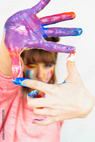 Happy woman hiding the face with her painted hands. Creative, art, childhood, drawing concept