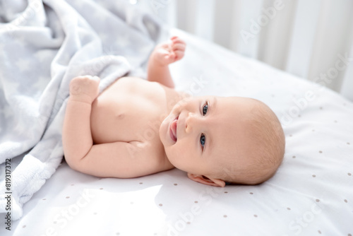 Cute little baby lying in crib at home
