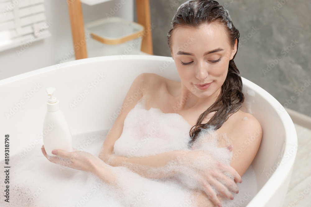 Woman taking bath with shower gel in bathroom Woman taking bath with shower gel in bathroom