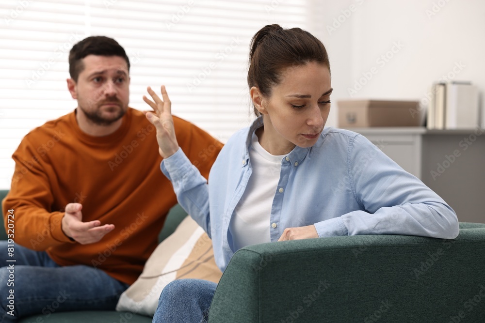Tired wife stopping her husband indoors, selective focus. Relationship problems Tired wife stopping her husband indoors, selective focus. Relationship problems