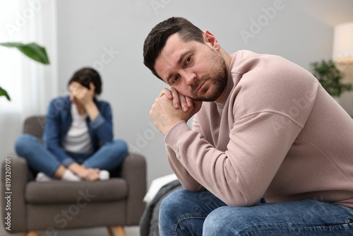 Offended couple ignoring each other after quarrel in bedroom, selective focus. Relationship problems