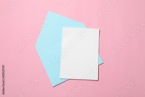 Letter envelope and card on pink background, top view © New Africa