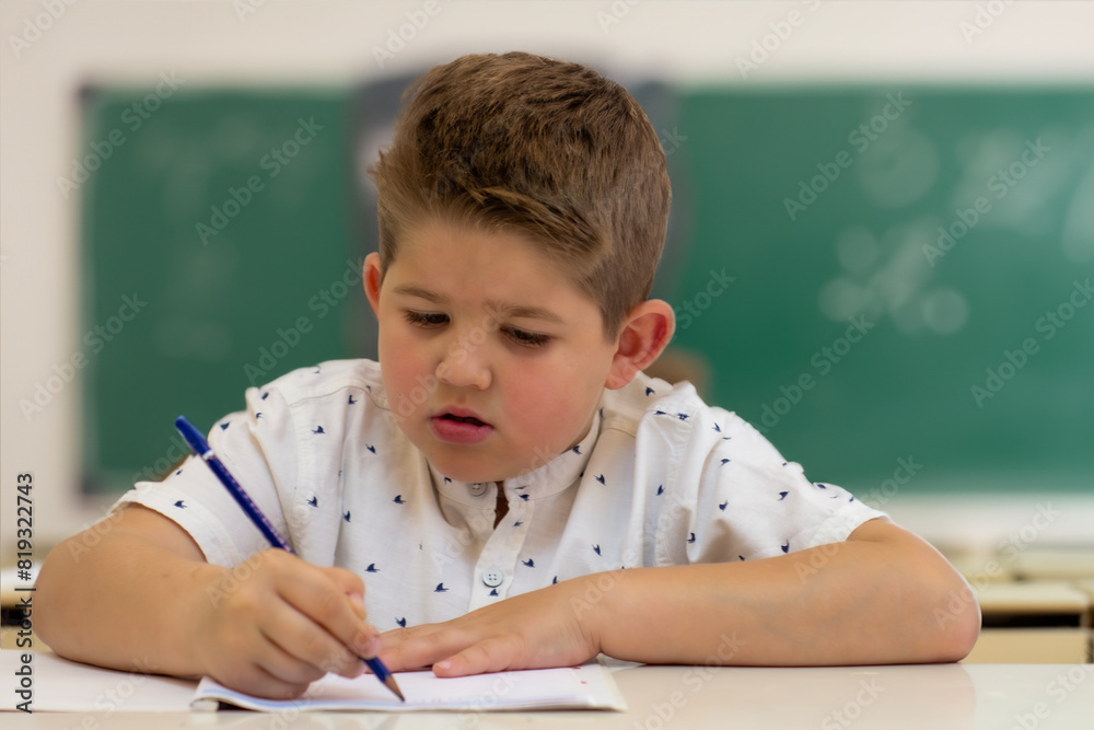 Distance learning education. Back to school. Cute kid boy studying at home and doing school homework. Thinking child sitting at table Distance learning education. Back to school. Cute kid boy studying at home and doing school homework. Thinking child sitting at table