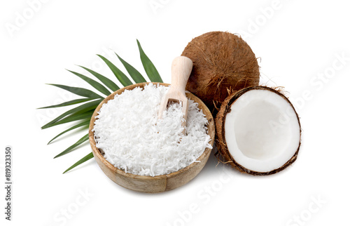 Coconut flakes in bowl, scoop, nuts and palm leaf isolated on white