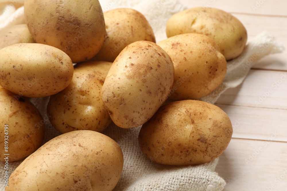 Raw fresh potatoes on light wooden table Raw fresh potatoes on light wooden table