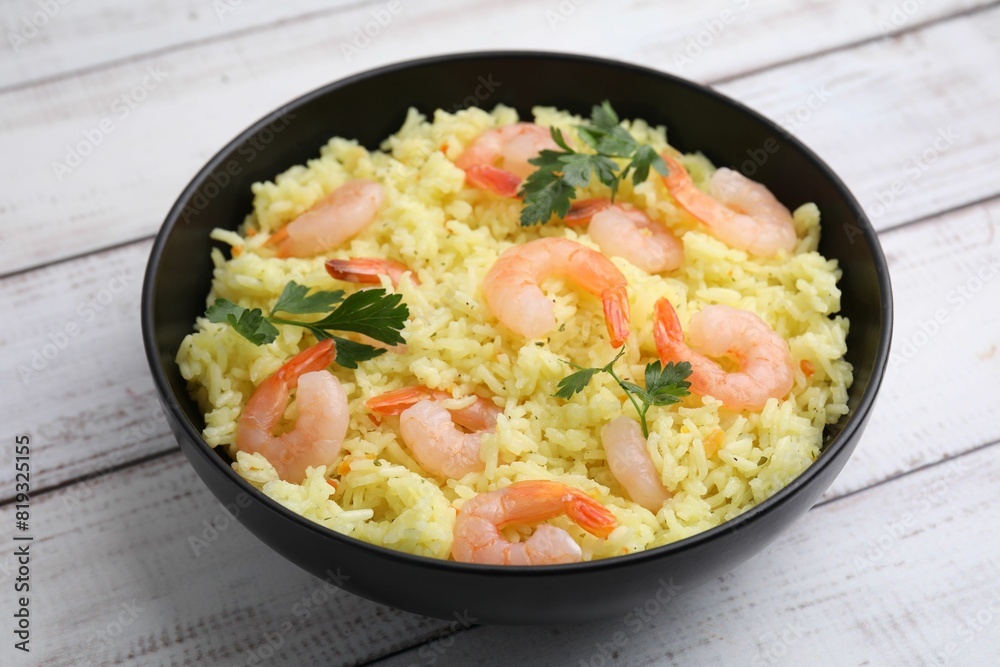 Delicious risotto with shrimps and parsley in bowl on white wooden table, closeup Delicious risotto with shrimps and parsley in bowl on white wooden table, closeup
