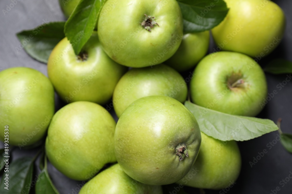 Ripe green apples with leaves on dark grey table, closeup Ripe green apples with leaves on dark grey table, closeup