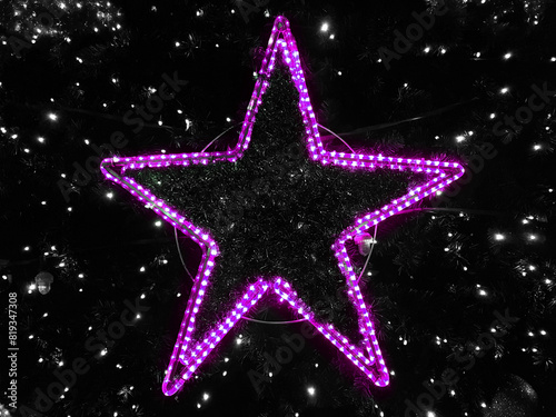 Shining pink star on the Christmas tree.