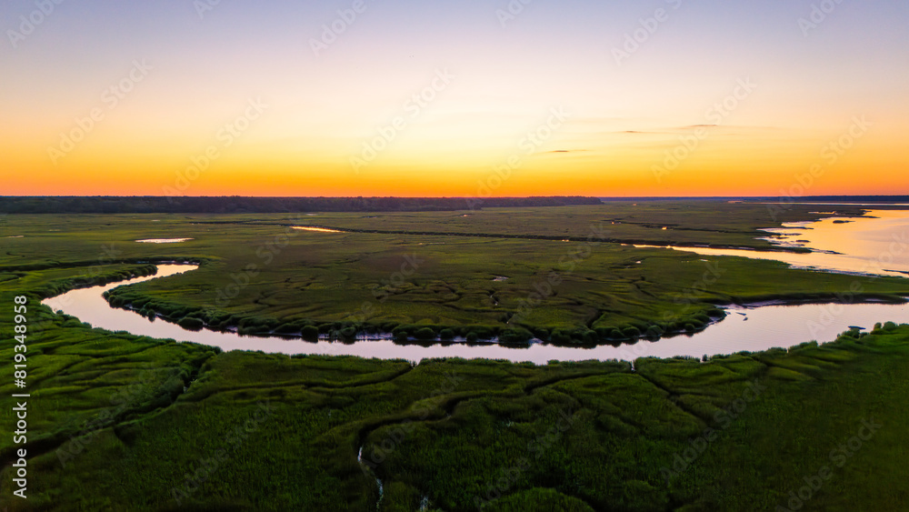 Naklejka premium Sunset over marsh landscape with reflection