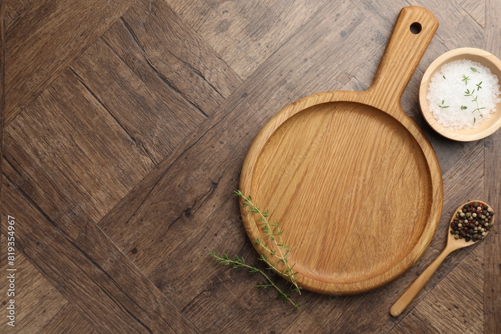 Cutting board and different spices on wooden table, flat lay. Space for text Cutting board and different spices on wooden table, flat lay. Space for text