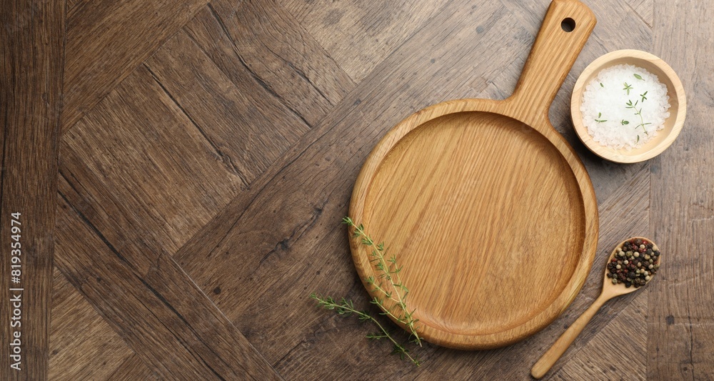 Cutting board and different spices on wooden table, flat lay. Space for text Cutting board and different spices on wooden table, flat lay. Space for text