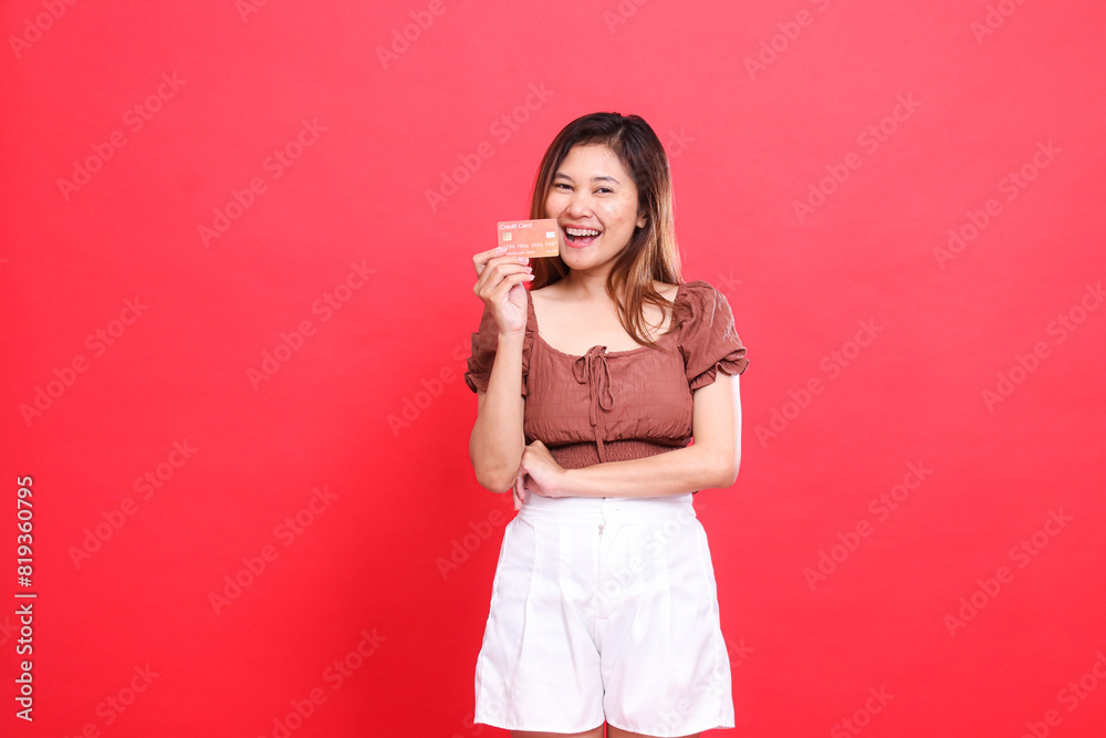 indonesia woman, happy, cheerful, holding her arms from the side, wearing a brown blouse with a red background. for transaction, technology and advertising concepts indonesia woman, happy, cheerful, holding her arms from the side, wearing a brown blouse with a red background. for transaction, technology and advertising concepts