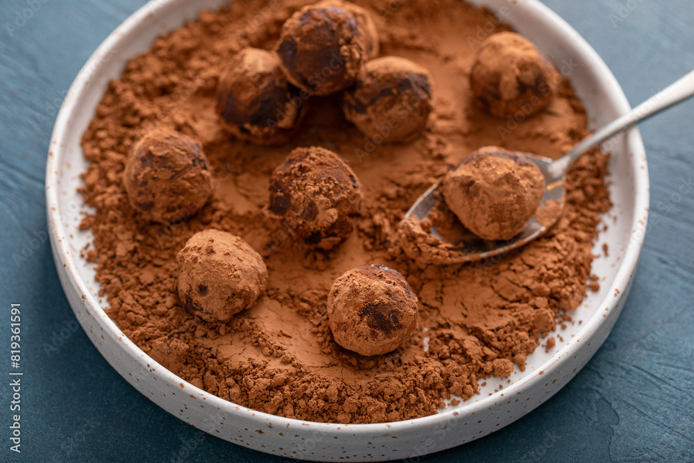 Artisanal chocolate truffles dusted with cocoa powder on a plate with a spoon Artisanal chocolate truffles dusted with cocoa powder on a plate with a spoon