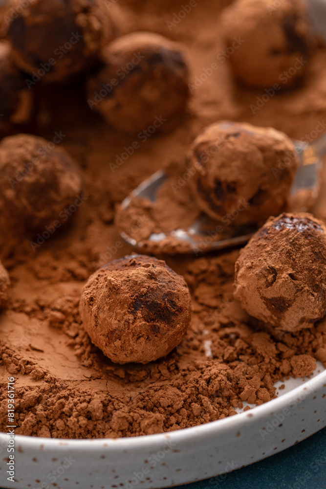 Artisanal chocolate truffles dusted with cocoa powder on a plate with a spoon Artisanal chocolate truffles dusted with cocoa powder on a plate with a spoon
