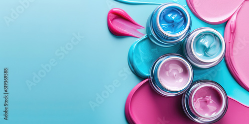 Opened jars of cosmetic cream on colored background with copy space.