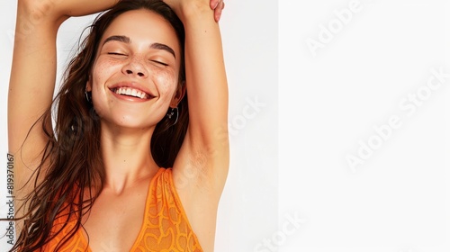 A beautiful woman smiling and holding her arms up, showing off the natural beauty of underarm skin with visible armpit hair on a white background, wearing an orange dress