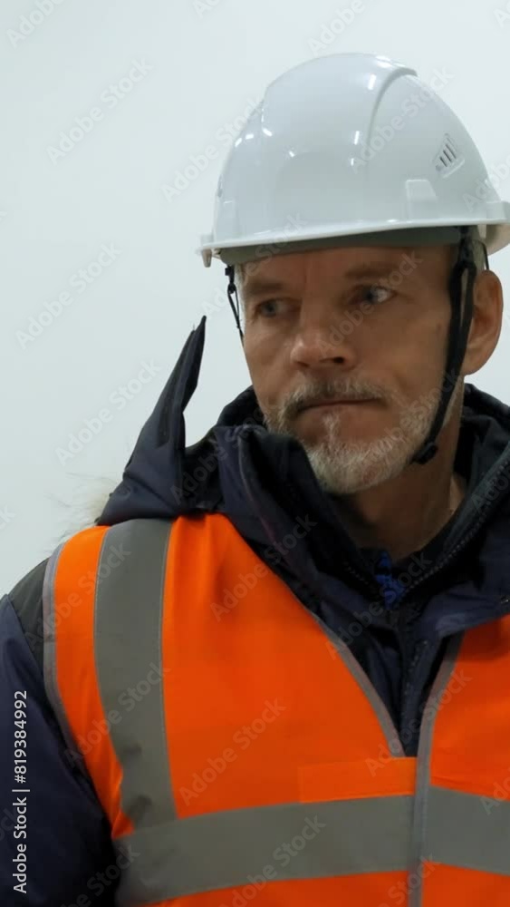 Senior man and blonde woman discuss project of improving warehouse. Experienced engineers in white hardhats stand in storage terminal closeup slow motion Vertical Shot. Senior man and blonde woman discuss project of improving warehouse. Experienced engineers in white hardhats stand in storage terminal closeup slow motion Vertical Shot.