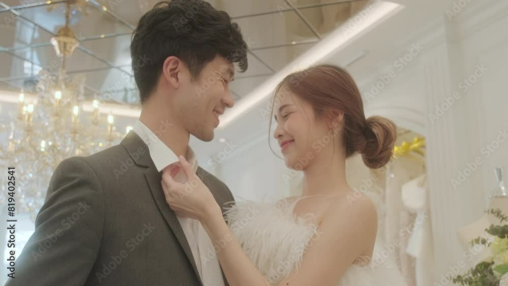 Young Asian couple enjoy preparatation for marriage caremony in fitting room at the bridal store. Young Asian couple enjoy preparatation for marriage caremony in fitting room at the bridal store.