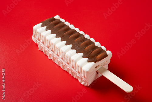 angle view vanilla and chocolate flavor popsicle on a red background photo