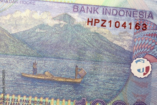 Rupiah Banknote type currency in Indonesia - Maitara and Tidore Islands, with fishermen on a boat photo