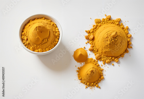 Turmeric (Curcuma longa Linn) powder pouring from wooden bowl with rhizome (root) slices on white background.