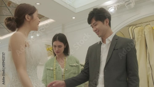 Young Asian couple enjoy preparatation for marriage caremony in fitting room at the bridal store. photo