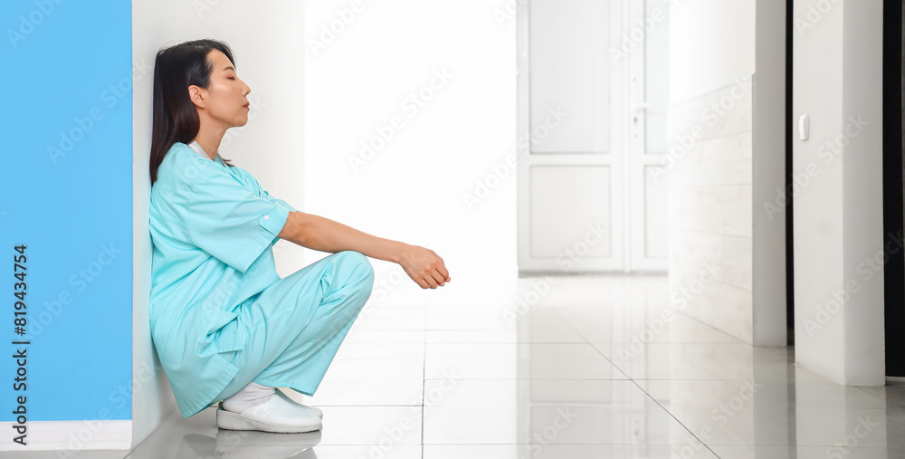 Stressed female Asian medical intern in clinic Stressed female Asian medical intern in clinic