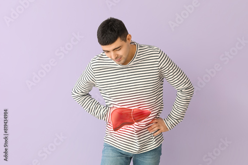 Young man with appendicitis on lilac background photo