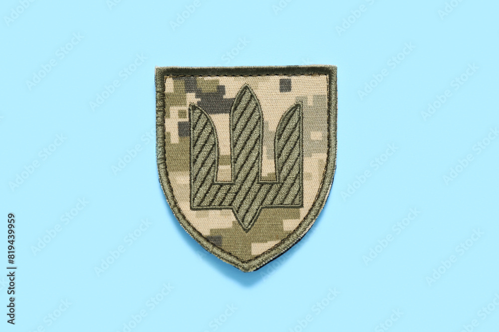 Military badge of Ukrainian army with trident on turquoise background Military badge of Ukrainian army with trident on turquoise background