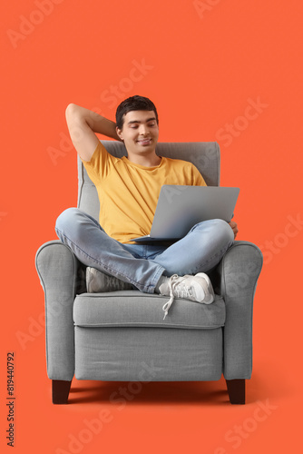 Young man with laptop sitti...