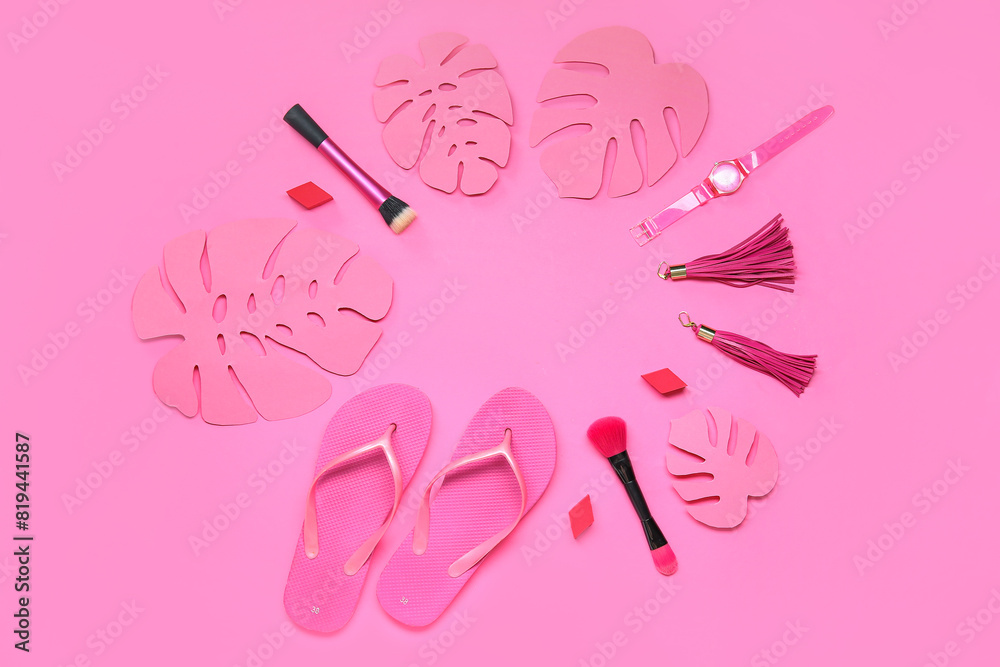Frame made of female accessories, flip-flops and paper palm leaves on pink background Frame made of female accessories, flip-flops and paper palm leaves on pink background