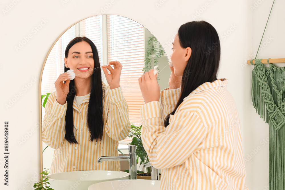 Beautiful young happy woman with dental floss in bathroom at home Beautiful young happy woman with dental floss in bathroom at home