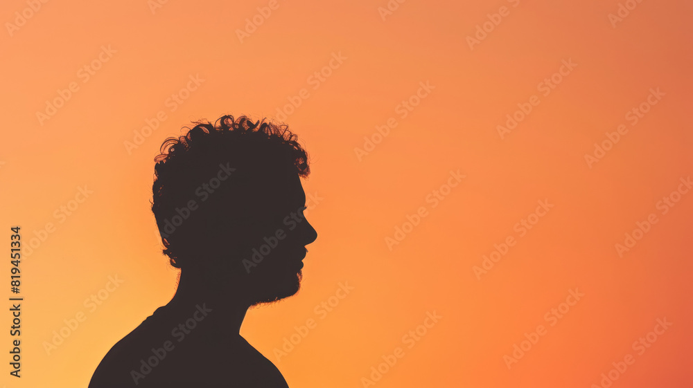 Silhouette of man with curly hair against orange sunset sky Silhouette of man with curly hair against orange sunset sky