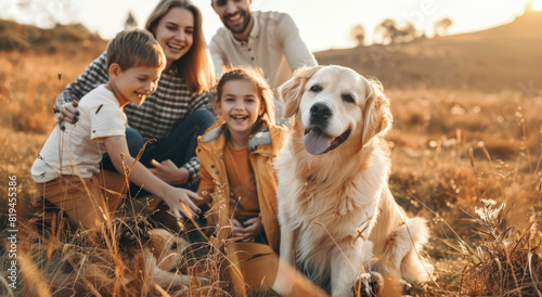 A happy family of four, including two children aged around five years and their mother with long brown hair smiling at the camera while playing together photo