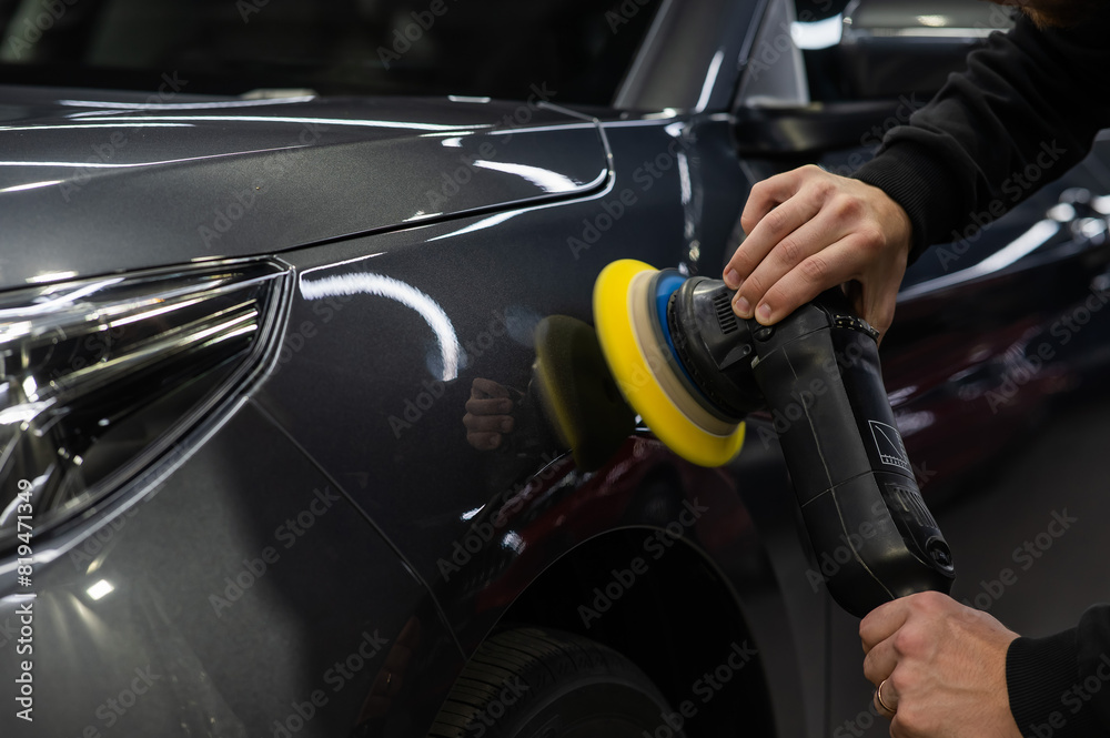 A master polishes the surface of a car body. A master polishes the surface of a car body.