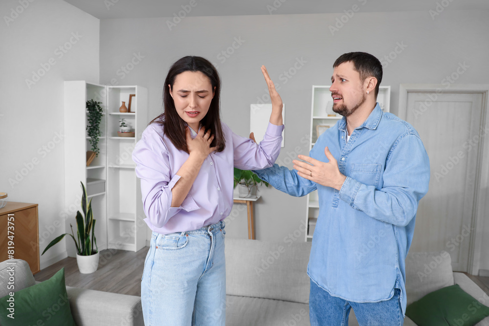 Fototapeta premium Young couple quarrelling at home. Cheating concept