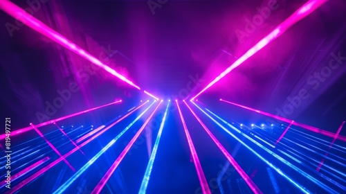 Against a deep black background, beams of bright blue and violet laser light shine, creating a vibrant and energetic display. The interplay of the two colors against the darkness enhances  © peerawat