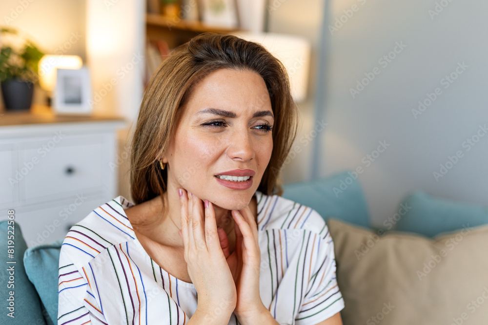 Close up of young woman rubbing her inflamed tonsils, tonsilitis problem, cropped. Woman with thyroid gland problem, touching her neck, girl has a sore throat Close up of young woman rubbing her inflamed tonsils, tonsilitis problem, cropped. Woman with thyroid gland problem, touching her neck, girl has a sore throat