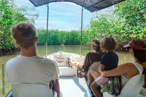View from behind of a Family on a wildlife estuary boat tour in Costa Rica. Exploring the Tamarindo estuary and river area looking for wildlife and the mangrove forests. Costa Rican Travel photo