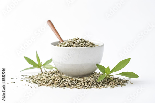 Dried tea leaves in a bowl with green leaves